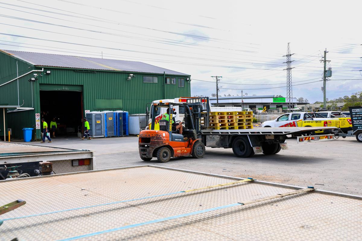 The TFH Brisbane yard: forklift loading a truck at the green shed